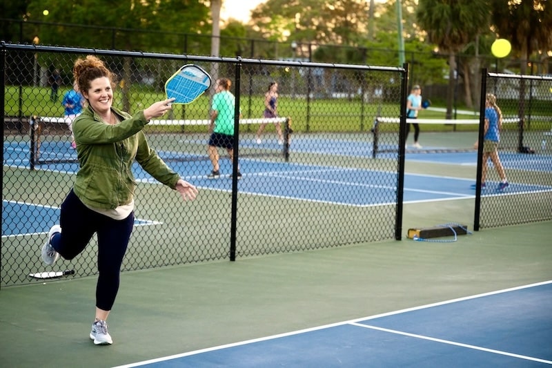 woman playing pickleball at a court